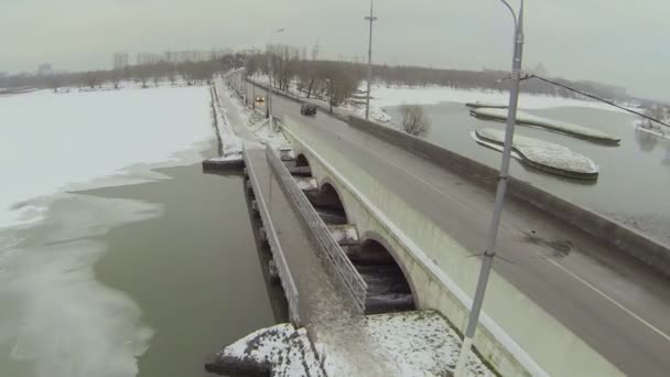 Auto's rijden door dam in de buurt van de stad — Stockvideo