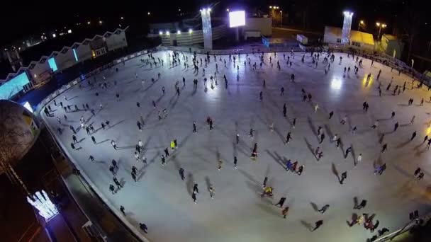 Mensen schaatsen op ijsbaan in recreatiepark — Stockvideo