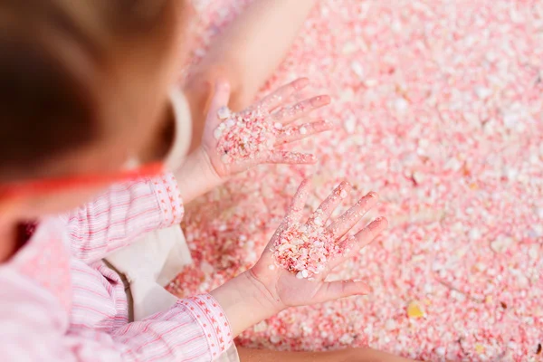 Meisje bedrijf roze schelpen — Stockfoto