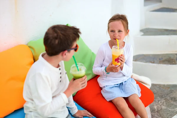 Duas crianças bebendo smoothies ao ar livre — Fotografia de Stock