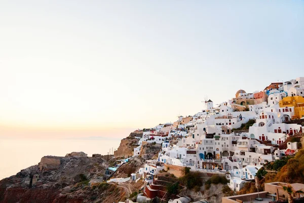 希腊圣托里尼岛上有着传统白色建筑和蓝色圆顶教堂的欧亚村令人叹为观止的日落景象 — 图库照片