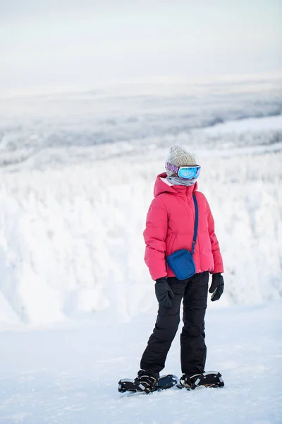 ラップランドの雪に覆われた木の間で冬の森の中でスノーシューズでかわいいプレティーンの女の子のハイキングフィンランド — ストック写真