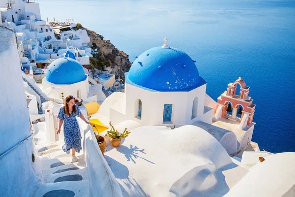 夏休みの美しい女の子サントリーニ島ギリシャのOia村の青いドーム型の教会の息をのむような景色を楽しむ — ストック写真