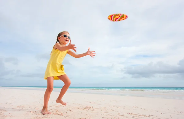 Маленькая девочка играет с летающим диском — стоковое фото