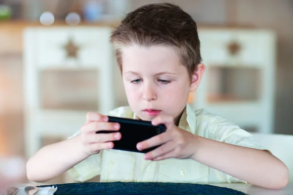 Menino jogando no telefone celular — Fotografia de Stock