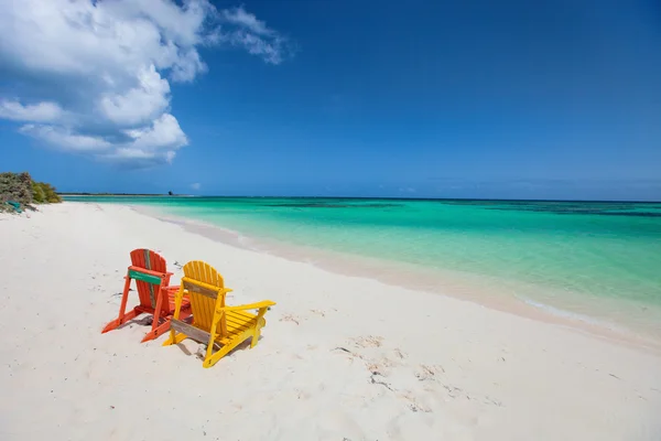 Färgglada adirondack solstolar på caribbean beach — Stockfoto
