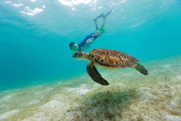 Мальчик плавает с трубкой с морской черепахой — стоковое фото