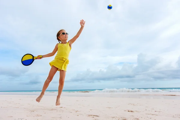 Mała dziewczynka gra tenis plażowy — Zdjęcie stockowe