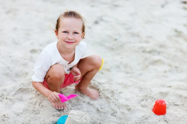 Liten flicka som leker på stranden — Stockfoto