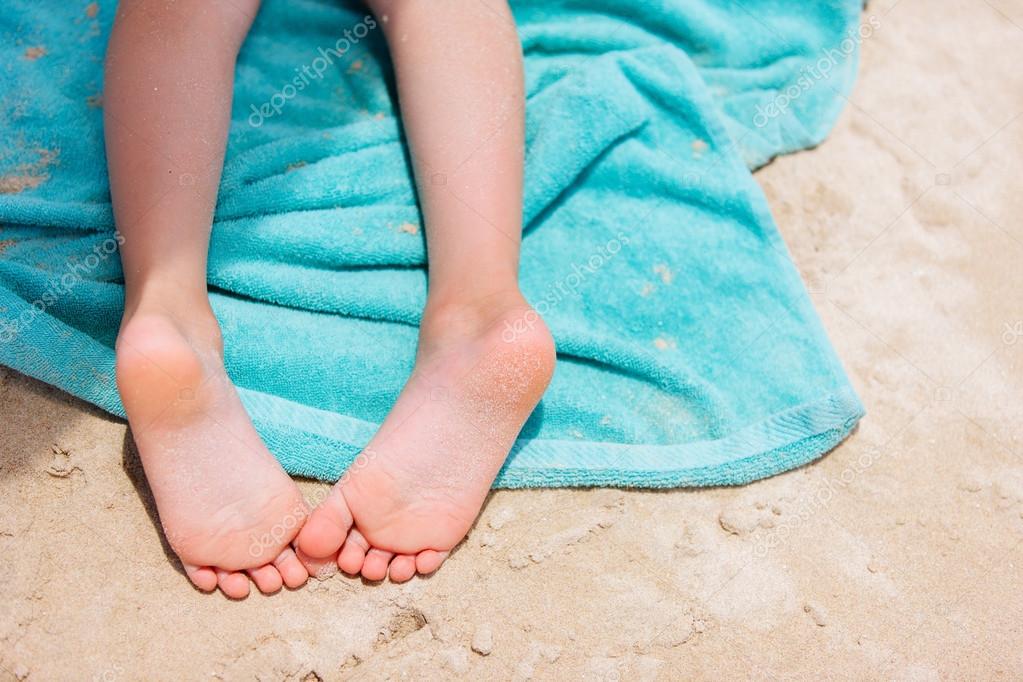 Little girl feet on a beach towel 