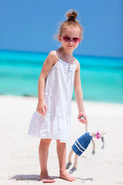 Маленькая девочка с игрушкой на пляже — стоковое фото