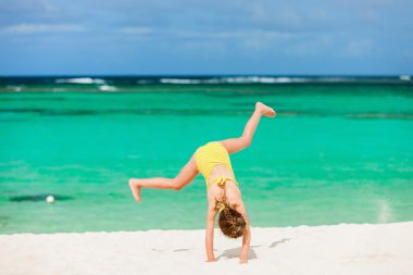 Cute little girl having fun on beach vacation clipart