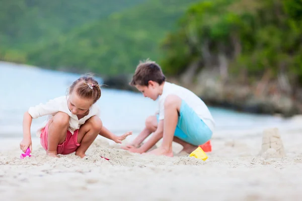 Två barn som leker på stranden — Stockfoto