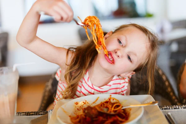 Liten flicka äter spaghetti — Stockfoto