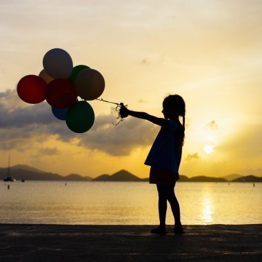 gün batımında balonlarla mutlu kız