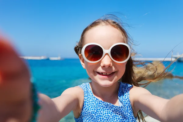 Очаровательная маленькая девочка делает селфи на открытом воздухе — стоковое фото