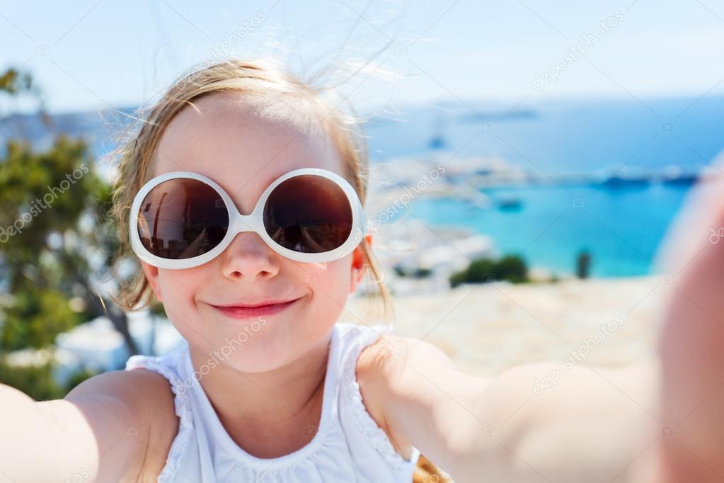 Adorable little girl making selfie outdoors