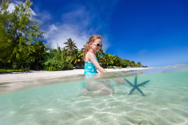 Menina brincando com estrela do mar — Fotografia de Stock