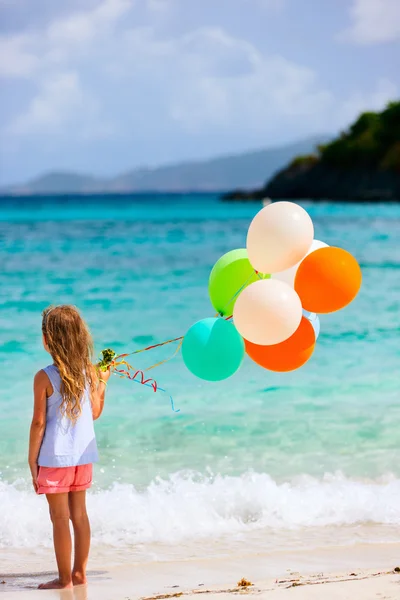 Rückansicht eines kleinen Mädchens mit Luftballons am Strand — Stockfoto