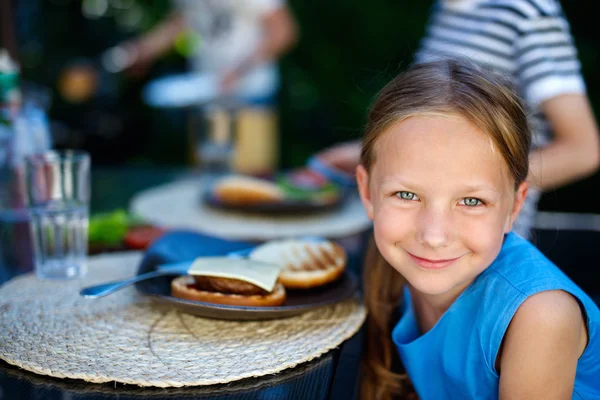 Маленькая девочка ест бургер — стоковое фото