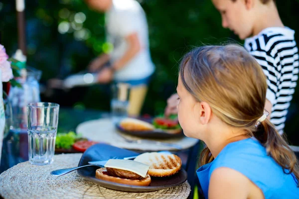 Liten flicka äter hamburgare — Stockfoto