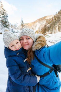 Mother and daughter outdoors at winter clipart