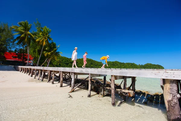 Moeder en kinderen op een tropisch strand — Stockfoto