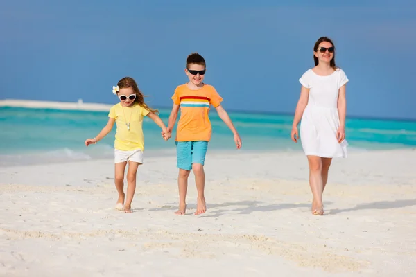 Moeder en kinderen op een tropisch strand — Stockfoto