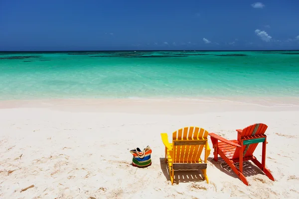 Färgglada adirondack solstolar på caribbean beach — Stockfoto