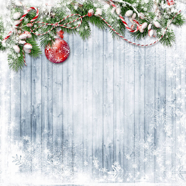 Christmas decorations with snowy berries, fir tree on a winter wooden background. Greeting postcard  with copy space