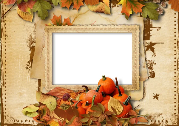 Гарбузи, осіннє листя і рамка для фото на старовинному фоні — стокове фото