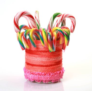 Dekoratif bir kavanozda beyaz arka planda lezzetli lolipoplar.