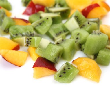 Dilimlenmiş şeftali ve beyaz tabakta kivi dilimleri.