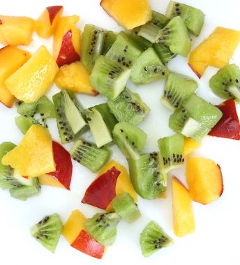 Dilimlenmiş şeftali ve beyaz tabakta kivi dilimleri. 