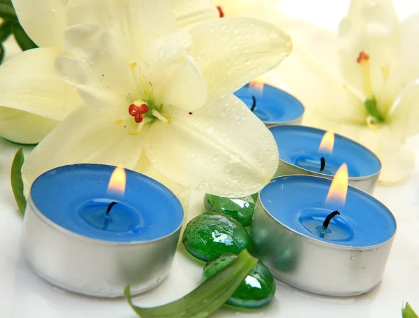 Lilies and burning candles — Stock Photo, Image