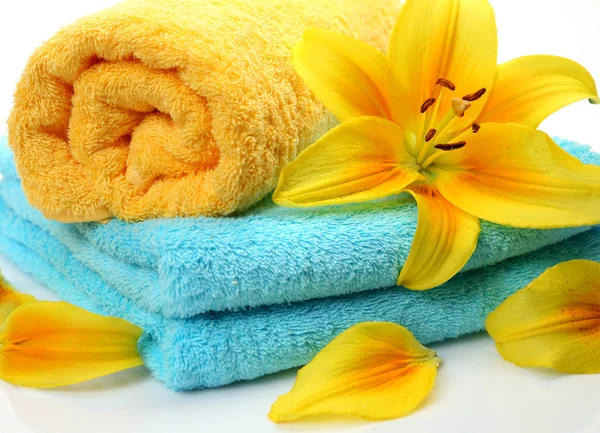 Towels and yellow lilies — Stock Photo, Image