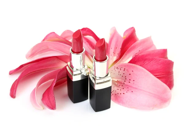Petals of a pink lily and lipsticks — Stock Photo, Image