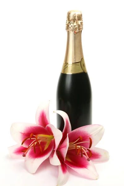 Wine bottle and lily flowers — Stock Photo, Image