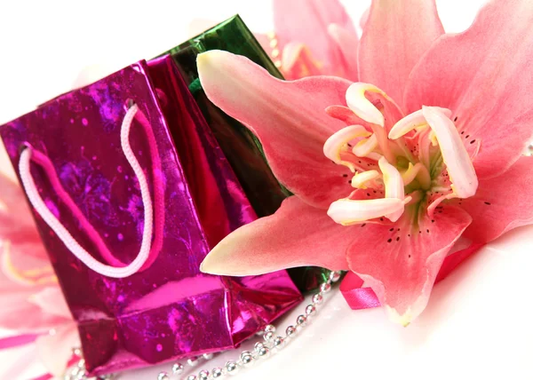 Dárky a růžové lilie — Stock fotografie