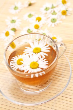 Papatya çiçekli bir fincan çay.
