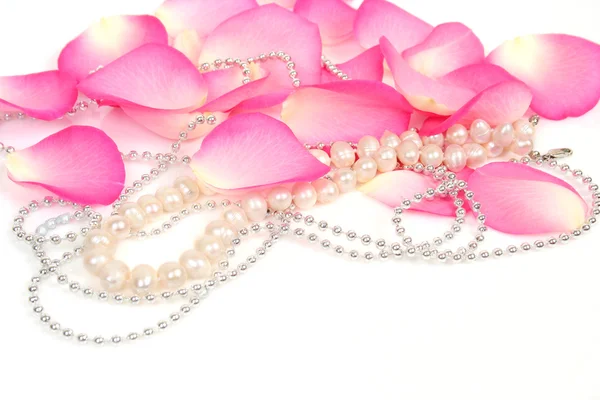 Petals of pink rose with necklace — Stock Photo, Image