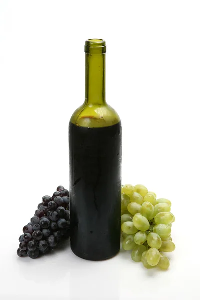 Láhev červeného vína a hroznů — Stock fotografie