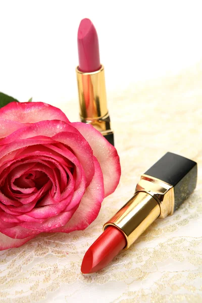 Red and pink lipsticks with rose Royalty Free Stock Images