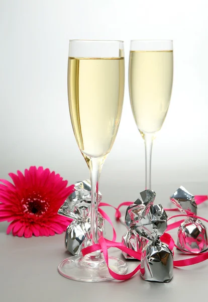 Gerbera with candies and glasses of champagne — Stock Photo, Image