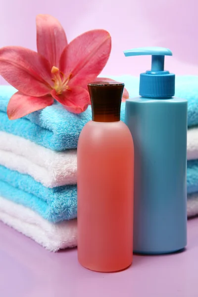 Towels with body care lotion bottles — Stock Photo, Image