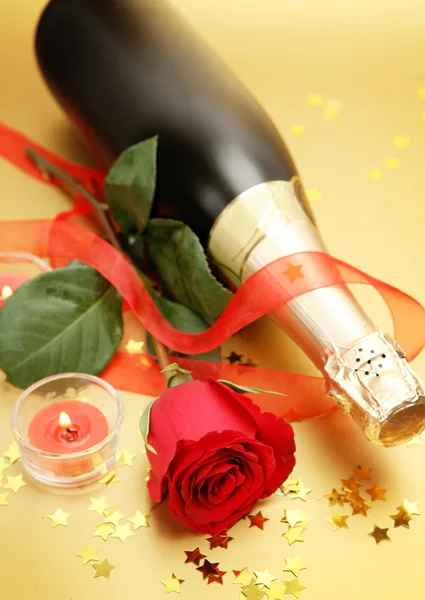 シャンパン、赤いバラ、燃焼キャンドルとリボン — ストック写真