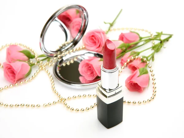 Rosa rosor, spegel och läppstift Stockbild
