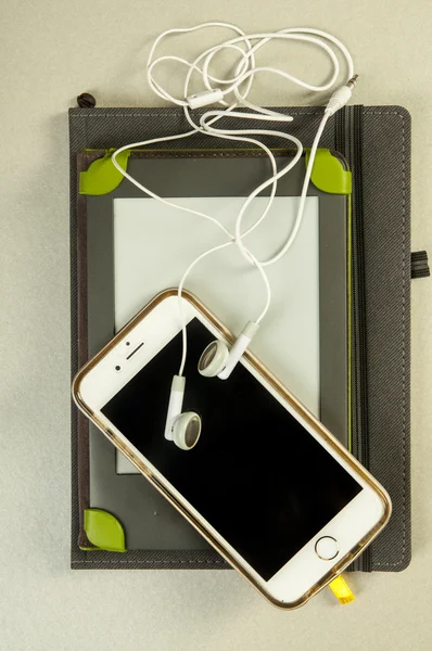 Notebook, e-bok och telefonen med hörlurarna — Stockfoto