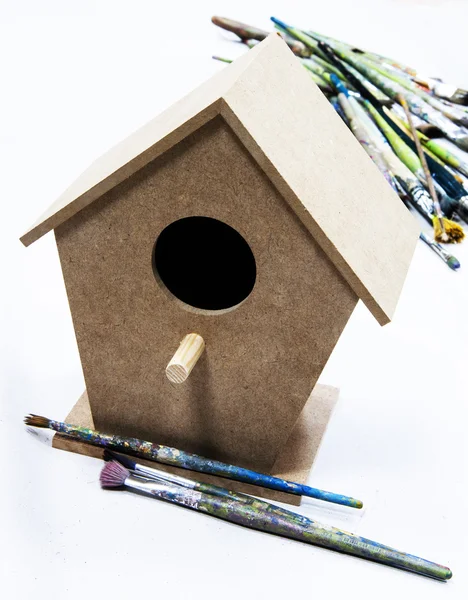 Brushes and wooden birdhouse — Stock Photo, Image