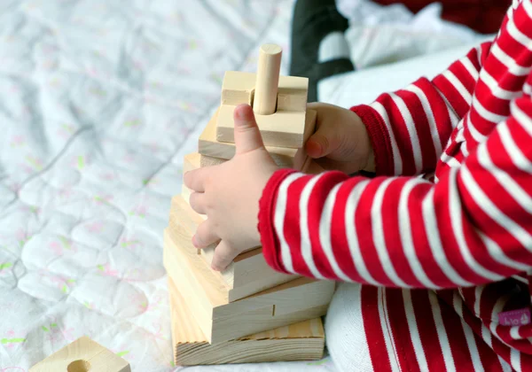 Bebé jugando con juguetes de madera simples — Foto de Stock